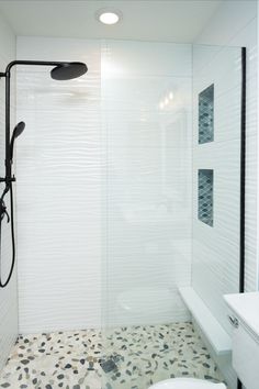 a bathroom with a walk in shower next to a toilet