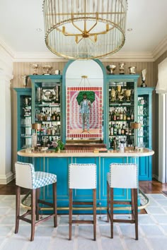 a blue bar with two stools in front of it and a painting on the wall