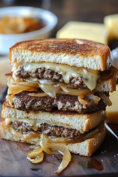 two grilled cheese sandwiches stacked on top of each other with onions and melted cheese