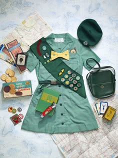 an assortment of items are laid out on top of a map, including a green coat and hat