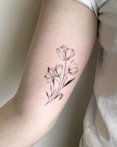 a woman's arm with a flower tattoo on the left side of her body