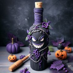 a wine bottle decorated with purple vines and pumpkins