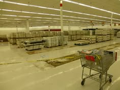 an empty shopping cart in a warehouse filled with pallets