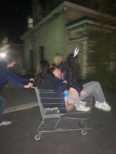 a group of people sitting in a shopping cart