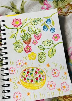 an open notebook with drawings on it and flowers around the page, including strawberries