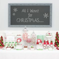 an all i want for christmas display with candy and candies in front of a chalkboard