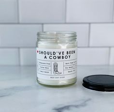 a glass jar sitting on top of a white counter next to a black lid covered jar