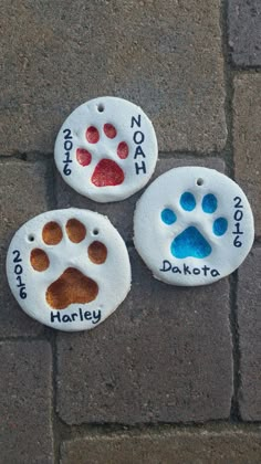 three painted rocks with dogs paw prints on them that say not to touch or not to touch