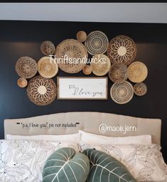 a bed with pillows and decorative wall hangings above it