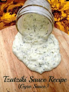 a jar filled with white sauce sitting on top of a wooden cutting board