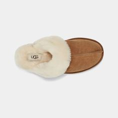 This essential house slipper is cast in soft suede and UGG's signature sheepskin. Pair with UUG cozy robes or matching cashmere sets for maximal leisure. Suede upper Sheepskin collar 17mm sheepskin lining 17mm sheepskin insole Molded rubber outsole Polyester binding or textile binding made from 100% recycled polyester fibers Woven label with UGG® logo on insole, Heat-embossed UGG® logo Style: 1106872 Cozy Robes, Ugg Scuffette, Ultra Classic, Suede Slippers, Slipper Shoes, House Slippers, Real Fur, Women Supporting Women, Me Time