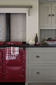 a red stove top oven sitting inside of a kitchen