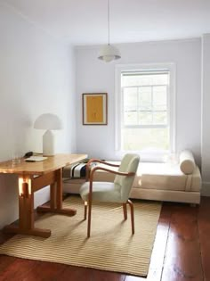 a living room with a couch, chair and desk in front of a window that reads play