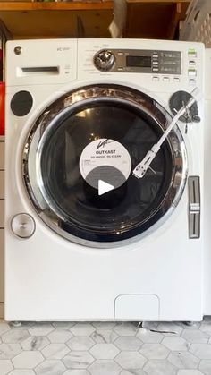 a washing machine sitting on top of a tiled floor