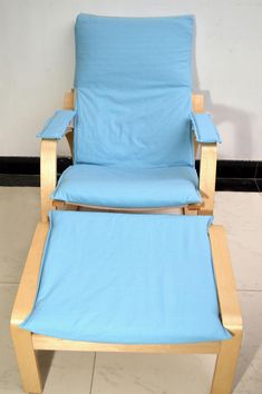 a blue chair and footstool sitting next to each other on tile flooring