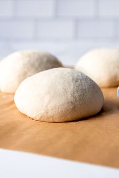 three uncooked doughnuts sitting on top of a cutting board