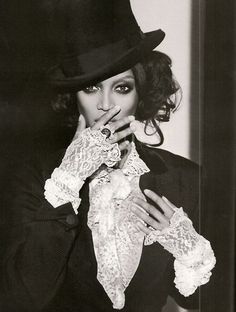 a black and white photo of a woman wearing a top hat