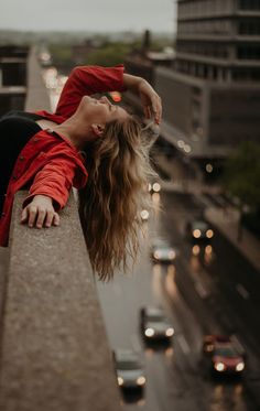 a woman leaning on the side of a building with her head down and eyes closed