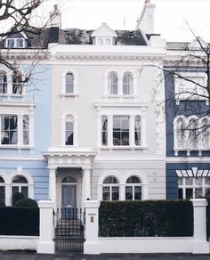 a large white and blue house sitting on the side of a road