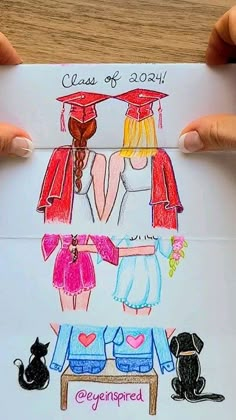 two girls in graduation gowns holding up a drawing