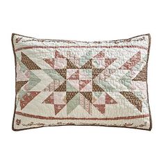 a white pillow with a pink and green patchwork design on the front, along with a brown border