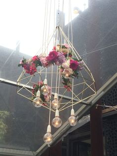 a chandelier with flowers hanging from it's sides