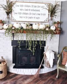 a fireplace decorated for fall with pumpkins and greenery