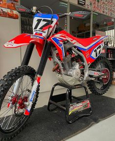 a red and blue dirt bike on display in a shop