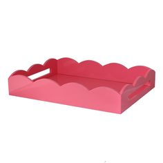 a pink plastic tray with scalloped edges and a handle on the bottom that is shaped like a heart