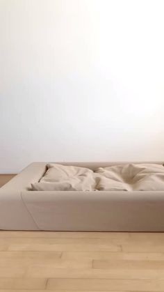 a white bed sitting on top of a hard wood floor