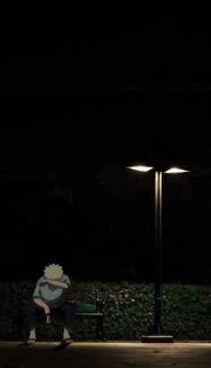 a person sitting on a bench under a street light at night with their back turned to the camera