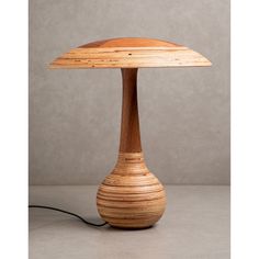 a wooden table lamp sitting on top of a white counter next to a gray wall