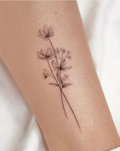 a small flower tattoo on the right side of the leg, it is black and white