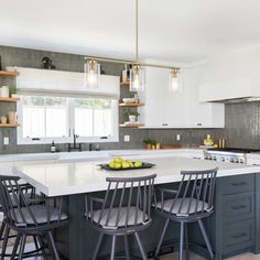 a kitchen island with four bar stools next to it