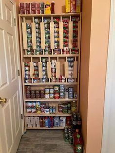 an open pantry with canned food and condiments on the shelves next to it