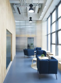 an empty office with blue chairs and tables