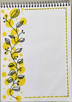 a spiral notebook with yellow and black flowers on the cover, next to a white sheet of paper