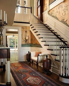 a staircase leading up to a living room with a couch and rug on the floor