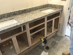 a bathroom with two sinks and cabinets under construction