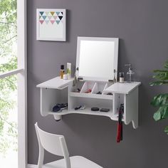 a white desk with a mirror and other items on it in front of a window