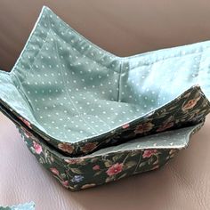 two fabric baskets sitting on top of a table next to each other with polka dots