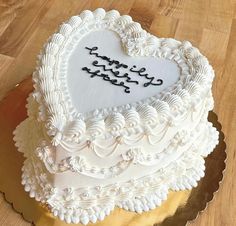 a heart - shaped cake with writing on it is sitting on a gold platter