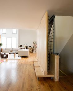 a living room with hard wood floors and white furniture