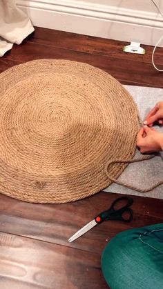 someone is making a hat out of jute on the floor next to some scissors