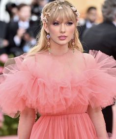 taylor swift wearing a pink dress with ruffles on the skirt and headband