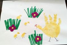 a paper plate with flowers and handprints on it that is made to look like grass