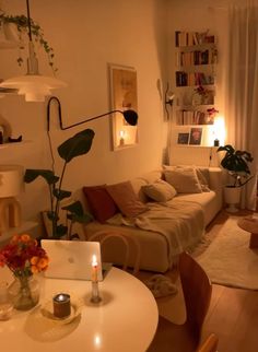 a living room filled with furniture and a laptop computer on top of a white table