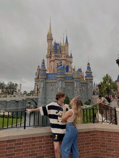 two people standing in front of a castle