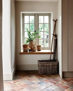 a window sill with plants in it next to a basket