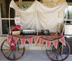 an old fashioned wagon is decorated with pink and white fabric for the tablecloths